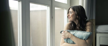 Nachdenkliche Person am Fenster – Stress und Haut