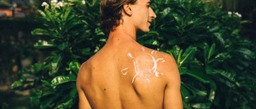 In Sonnenform aufgetragene Sonnencreme auf der Schulter – Sonnenschutz