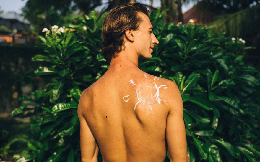 In Sonnenform aufgetragene Sonnencreme auf der Schulter – Sonnenschutz